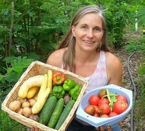 Marjory in garden holding veggies 320x289