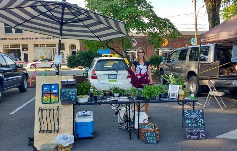 Find local farmers at your local farmers market. Here, the author sells greens and other goodies at her local market. (The Grow Network)